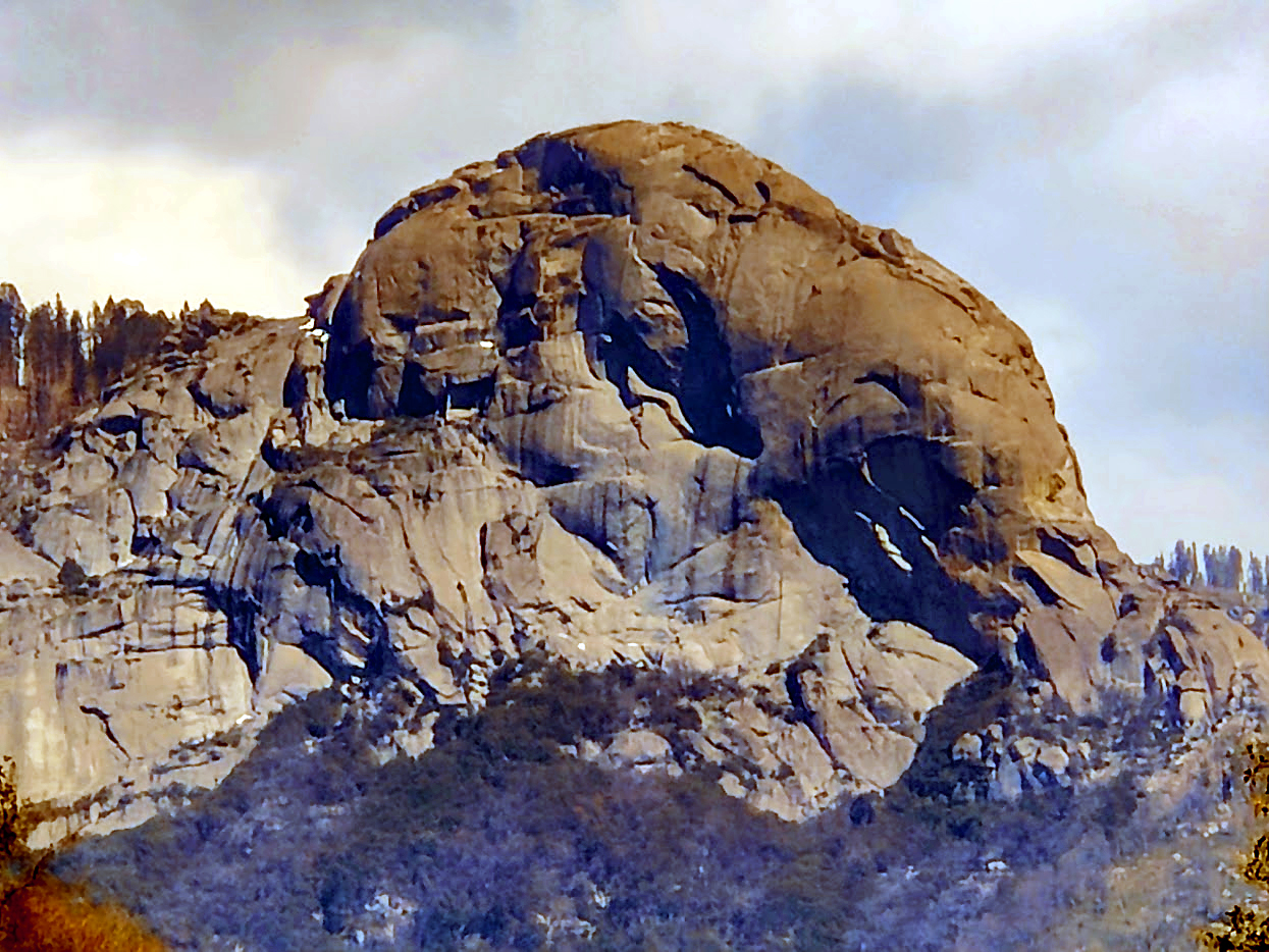 Granite dome of Moro Rock rising above the Sierra Nevada alpine forest canopy